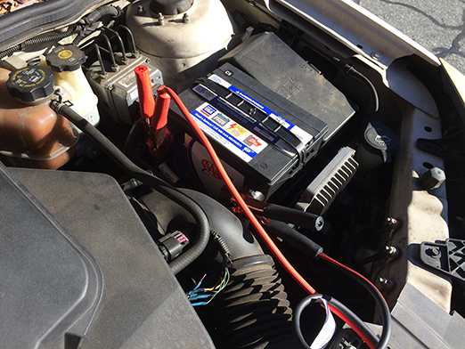 jumper cable terminal connected to positive and negative terminals of donor car