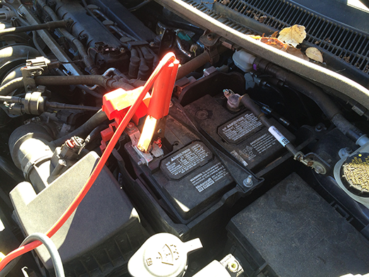 jumper cable terminal connected to positive terminal of a weak battery